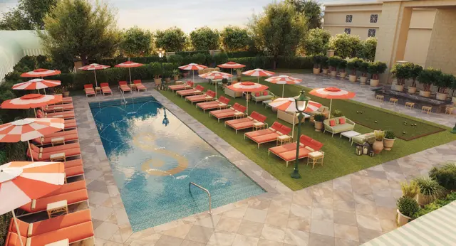 The Stoneleigh&rsquo;s outdoor pool, lined with orange loungers and umbrellas.
