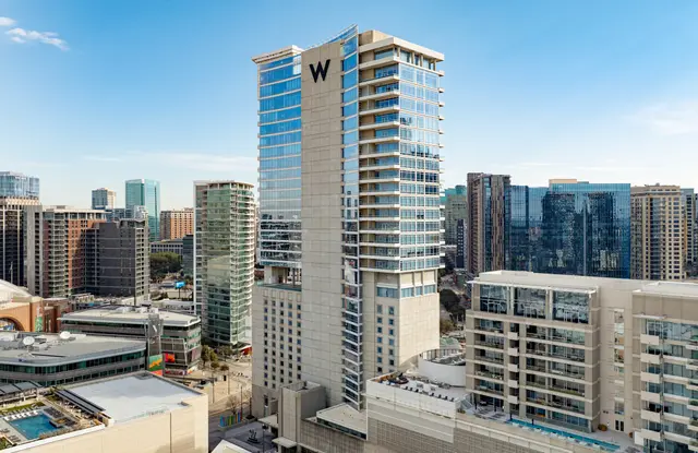 The W Dallas tower in Victory Park against the Dallas skyline.